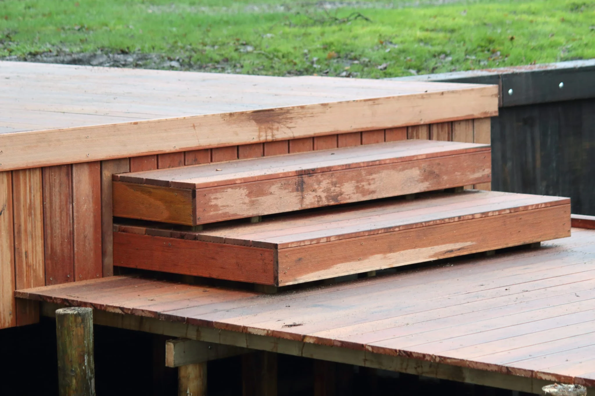Detail van het hardhouten vlonderterras met trap, boven het water